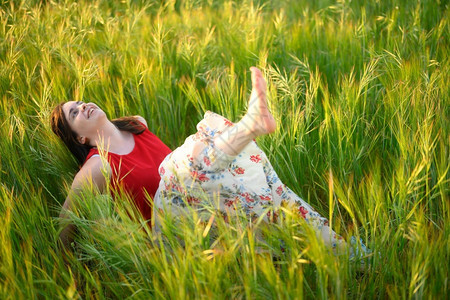 女在夏天日落的草原上放松高品质的照片女在夏天日落的草地上放松休息脚丫子场地图片