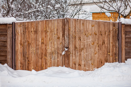 木头冰雪花园大门暴风雪后的木门冬季背景暴风雪后的木门闩锁图片