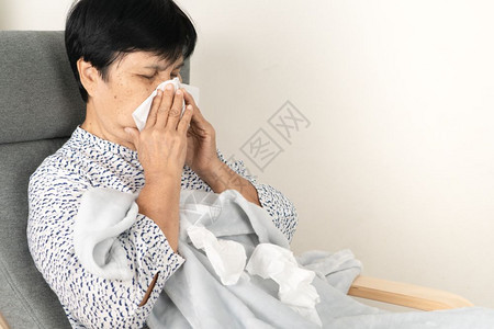 热的身穿羊毛毯病人躺在沙发上睡纸烧图片