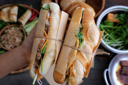 女人的手可以做banhmithit或越南面包有名的街头食物来自原料猪肉火腿梨子蛋和新鲜草药如扇菜椰胡萝卜黄瓜辣椒美味的脑袋丰富多图片