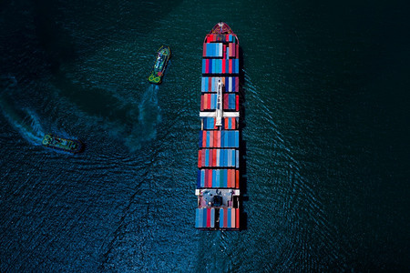 无人机物流黑色的集装箱货船在夜间飞行过程中从无人驾驶飞机空中向公海航行的集装箱货船在国际海上的货运集装箱船轮国际商业运图片