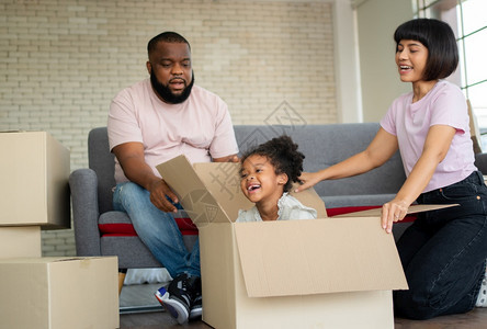 人们真实的搬迁混合种族家庭在购买房地产后第一天搬到新房子后就坐在沙发上休息新的家庭开始生活的概念是新家庭开始生活的概念图片