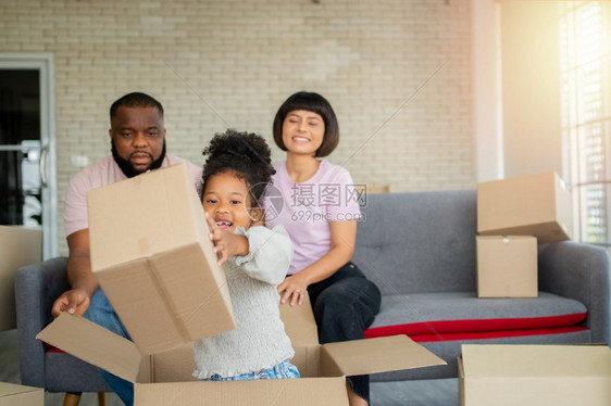 混合种族家庭在购买房地产后第一天搬到新房子后就坐在沙发上休息新的家庭开始生活的概念是新家庭开始生活的概念快乐母亲坐着图片