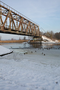冷冻下雪的里加市拉脱维亚托旧铁路桥和冬季河道空气图片
