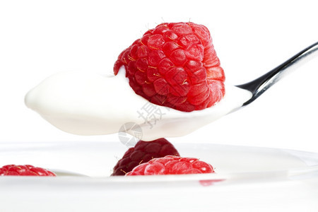 浆果甜点上加红莓和白底草的甜点上用酸奶汤勺子上的松莓和酸黄密闭用奶汤匙上加橙子奶油一种图片