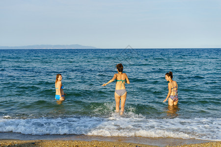 水夏天3名年轻女孩朋友在海边或的滩上穿着比基尼泳衣渡假日阳光明媚年轻的图片