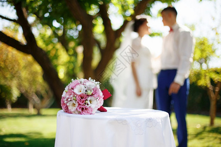 粉色的装饰风格以新娘和郎结婚概念为背景在花园的桌子上用粉红白花朵举行婚嫁新娘花束子礼昂贵的背景图片