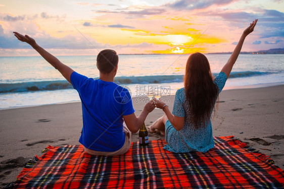 假期女孩在热带海滩上快乐的美丽家庭一起野餐在夕阳日落一家在海滩上野餐白种人图片