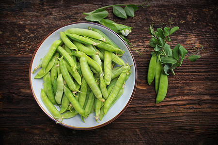 季节甜的木桌背景碗中绿豌豆顶视图木桌背景碗中的绿豌豆顶视图成熟图片