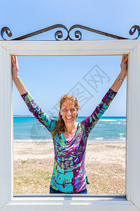 透视在希腊凯法洛尼亚海岸的蓝和滩附近的窗户上欢乐欧洲妇女白种人脸图片