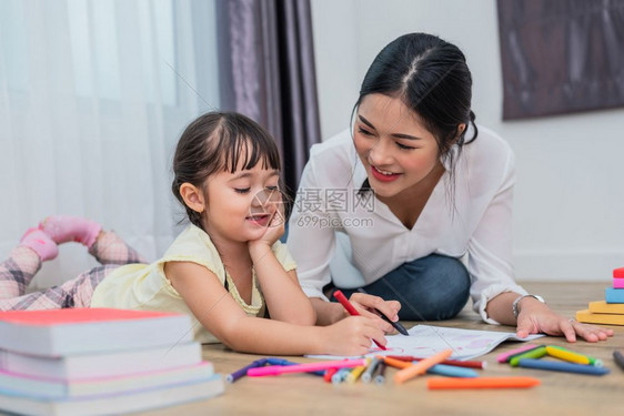 女孩纸妈教她儿在艺术课上画回到学校和教育概念孩子和主题家庭甜蜜的主题妈教她女儿绘画士图片