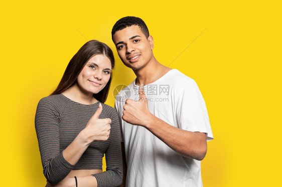 黄色的照片中一对惊人的夫妇展示合金符号与优质产品相同身穿散装衣孤立黄色背景积极的随意图片