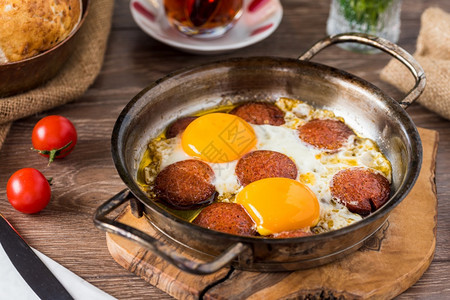 胖的土耳其传统早餐用土耳其香肠面包番茄和茶的炸鸡蛋油不良图片
