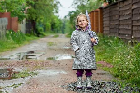 外套天气靴子夏走在雨中的小女孩打着雨伞水坑夏天走在雨中的小女孩打着雨伞图片