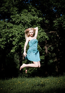 跳跃大自然背景下的漂亮女孩跳高自然背景女红色的图片