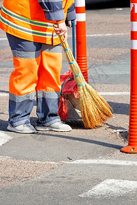 走道城市团队合作一名身着明橙色制服的女清洁工在街道上横扫一圈栅栏用橙色路柱围成垂直图像复制空间图片
