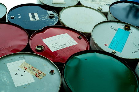 生锈的制造业蓝色绿和红油桶钢铁储箱有毒废物仓库危险化学桶加上警告标签包装桶中工业废物厂危险储存中的工业废物危险化学品桶背景