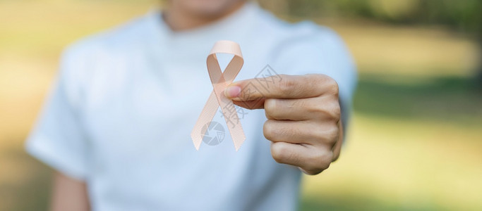 手握桃色丝带预防癌症概念图片