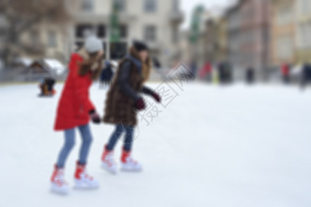 公园冬天快乐的人在溜冰场户外冬季活动散焦的户外溜冰场与滑人在寒假季节快乐的人在溜冰场户外冬季活动鞋图片