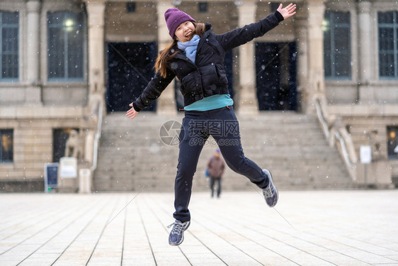 面漆自然玩雪和跳的亚洲年轻女当雪刚下来时旅行和兴奋的概念带毛帽夹着丝巾和外套在冬季过跌倒图片