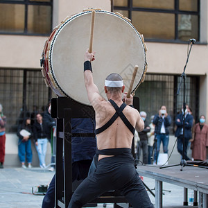 乐趣节奏亚洲人头带男子在公共外出活动期间播放日本音乐传统垂直鼓式剧团的声响图片