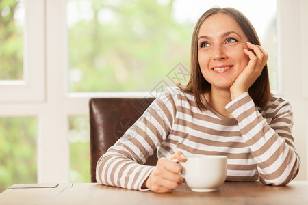 幸福室内的房间黑发女人在家中坐着想喝咖啡时笑图片