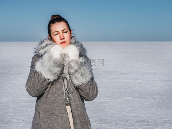 快乐年轻女在雪地的背景一个晴朗阳光明媚的一天幸福女在雪地背景肖像观美丽图片