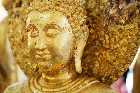 披着金叶背景的亚洲佛祖紧贴近了信仰白色的冥想图片