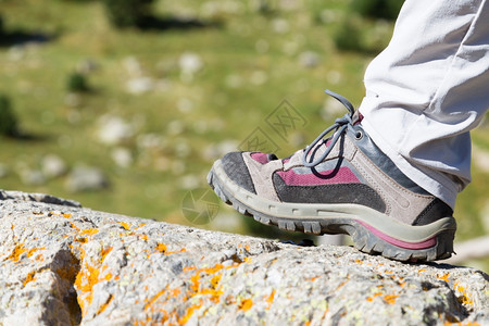 自由灵感动机在努里亚谷的一块岩石上徒步远足靴子图片