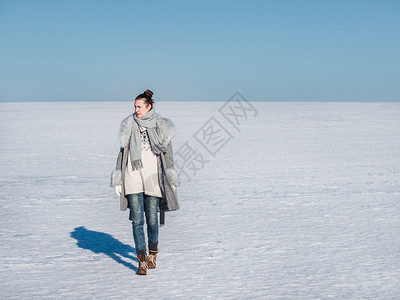 公园太阳白色的快乐年轻女在雪地的背景一个晴朗阳光明媚的一天幸福女在雪地背景图片