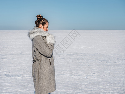 景观户外一种快乐年轻女在雪地的背景一个晴朗阳光明媚的一天幸福女在雪地背景图片