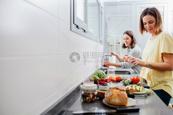 女沙拉家庭主妇两名女在厨房柜台准备健康食品饮和营养概念两名妇女图片