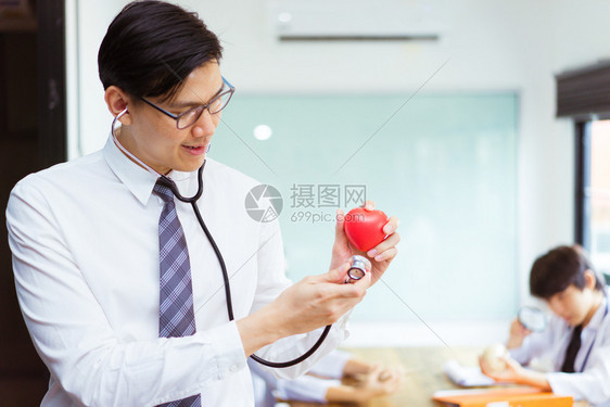 办公室人类医生使用听诊器检查心脏模拟医疗人员在背景上药物图片