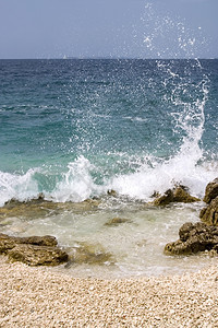 蓝海浪坠落在岩石岸喷湿的照片图片