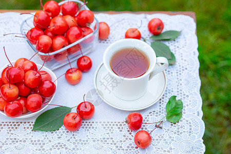 健康早上在花园里喝一杯带天堂苹果的白热茶自然背景模糊早上好在花园里喝一杯带天堂苹果的白热茶自然背景模糊树叶一种图片
