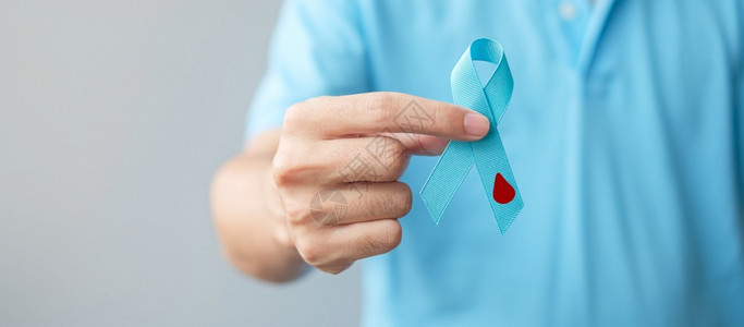 保险国际的医院世界糖尿病日提高认识月1男子持有带血滴状的浅蓝丝带以支持人们生活预防和疾病保健前列腺癌症日概念人类携带轻蓝丝和血滴图片