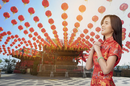 新年节庆月亮快乐新年节女红青山穿亚洲女人红礼服亚裔女人红礼手祈求好运祝幸福的女孩笑脸在庆祝新年节日人们希望图片