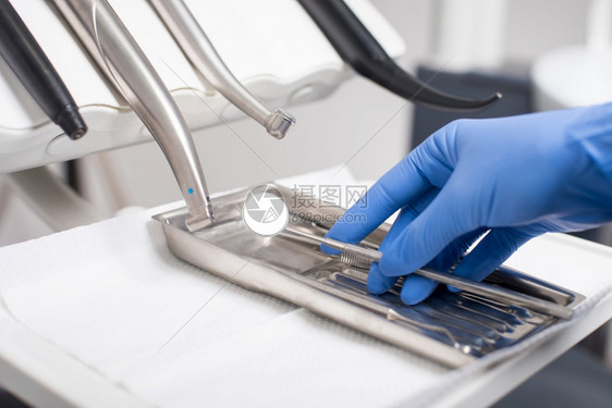 医院内阁健康戴手套的牙医在科办公室中采集牙科工具关闭有选择重点的戴手套牙科医在办公室中采集牙科工具单位图片