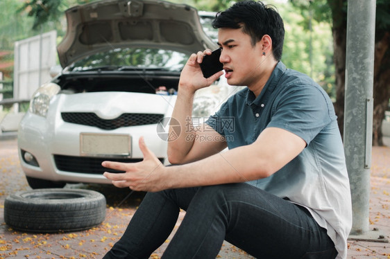 驾驶手机愤怒的亚洲男子在街头汽车故障后使用移动电话求救车辆发动机问题概念或事故以及专业技工的紧急帮助职业机械师提供紧急帮助司机路图片