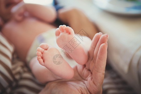 母亲手中的婴儿脚妈和她的孩子幸福家庭概念美好的母概念形象亲把婴儿抱在手里女人的握着新生婴儿的脚概念投标快乐图片