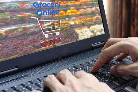 内部的商业手用膝上型电脑在杂货店内部背景的模糊超级市和零售商店的屏幕上使用网杂货机产品图片
