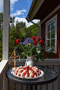 屋植物群喜庆的夏季装饰品配有草莓蛋糕鲜花和小红放在门廊的桌子上图片