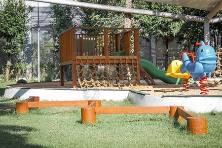 在公园操场的多彩上为儿童在公园中摇动马滑球和平衡梁安静的闲暇绿色图片