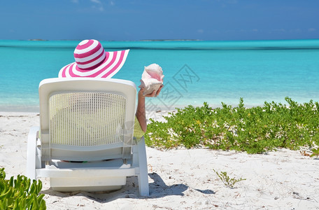 在巴哈马Exuma海滩上戴着条纹帽子的女孩边缘保护太阳图片
