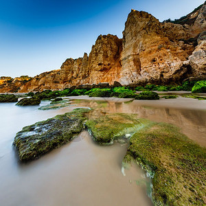 欧洲葡萄牙阿尔加维拉各斯波图德莫海滩的绿石早晨浪潮图片