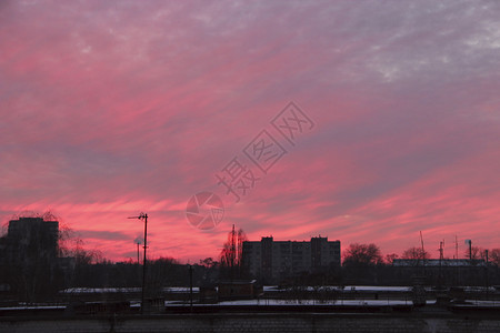 太阳朱红景观色日落在多层房屋之上夜晚城市景色风黄昏在紫光镇的暮市风云夜城红夕阳上大粉色乌云在晚城边的大粉色乌云图片