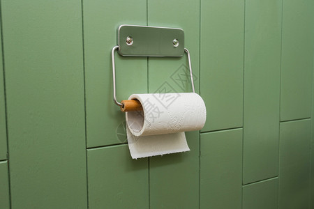 一卷白色软卫生纸整齐地挂在绿色浴室墙上的现代镀铬支架上现代设计一卷白色软卫生纸整齐地挂在绿色浴室墙上的现代镀铬支架上夹具厕房间图片