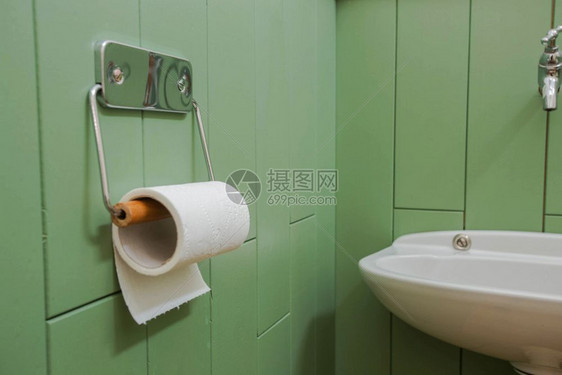一卷白色软卫生纸整齐地挂在绿色浴室墙上的现代镀铬支架上现代设计一卷白色软卫生纸整齐地挂在绿色浴室墙上的现代镀铬支架上角度柔软的颜图片