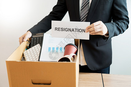 人们在棕色纸板盒和辞职信上携带包装个人公司的商因辞职或离失业辞概念而或更换工作失业和辞职的信年轻棕色图片