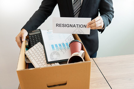 经理职业在棕色纸板盒和辞职信上携带包装个人公司的商因辞职或离失业辞概念而或更换工作失业和辞职的信女士图片